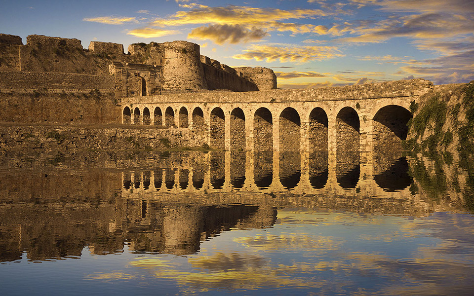 Venetian fortress arches reflected in still water in the Peloponnese